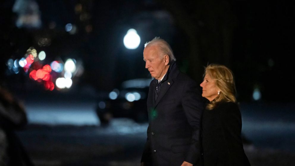 Joe Biden y su esposa Jill, abrigados con sobretodos, cruzan la calle durante una fría jornada en Estados Unidos