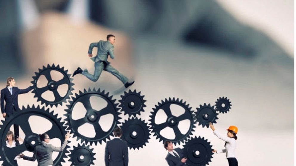 Businesswoman looking at team of businesspeople in miniature