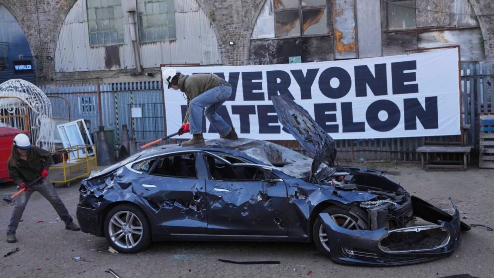 Manifestantes golpean un vehículo Tesla que iba a ser desechado, durante un evento organizado por el grupo "Todo mundo odia a Elon" el 10 de abril de 2025 en Londres. (AP Foto/Kirsty Wigglesworth)