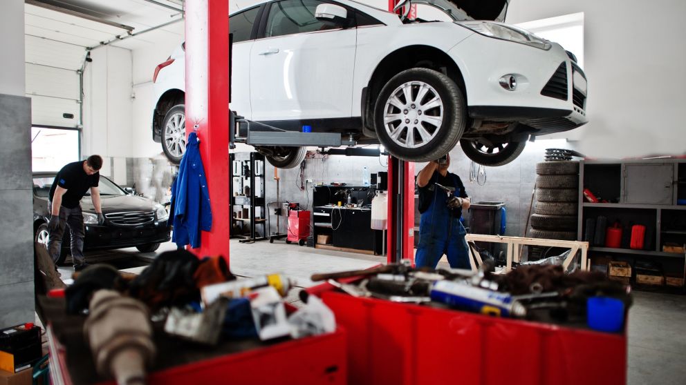 Car repair and maintenance theme. Mechanic in uniform working in auto service.
