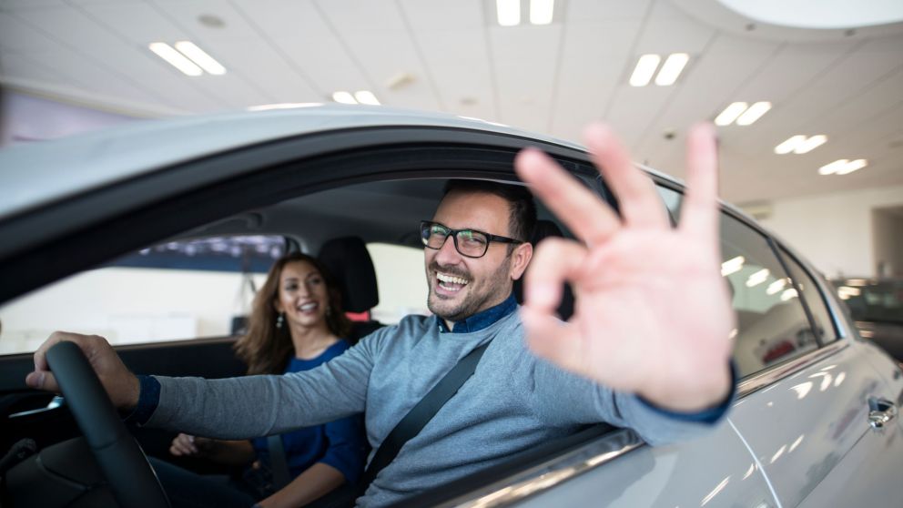 Happy customer buying new car at dealership.