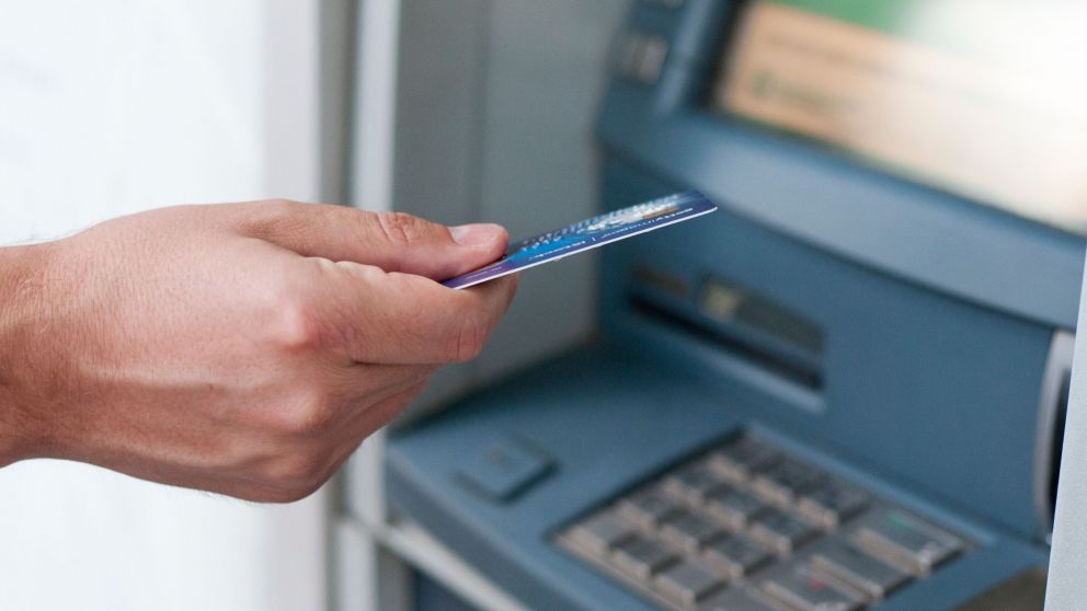 Hand inserting ATM card into bank machine to withdraw money. businessman men hand puts credit card into ATM