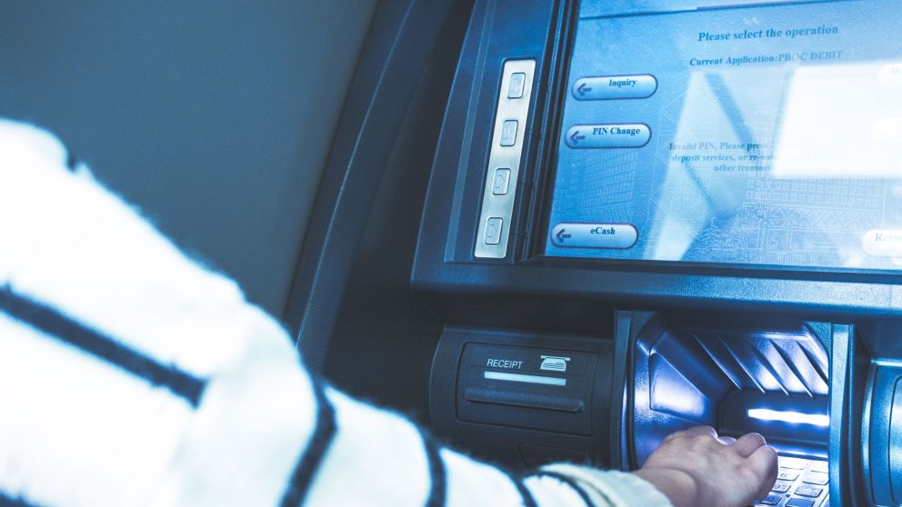 Woman using cash machine-ATM,close up view.