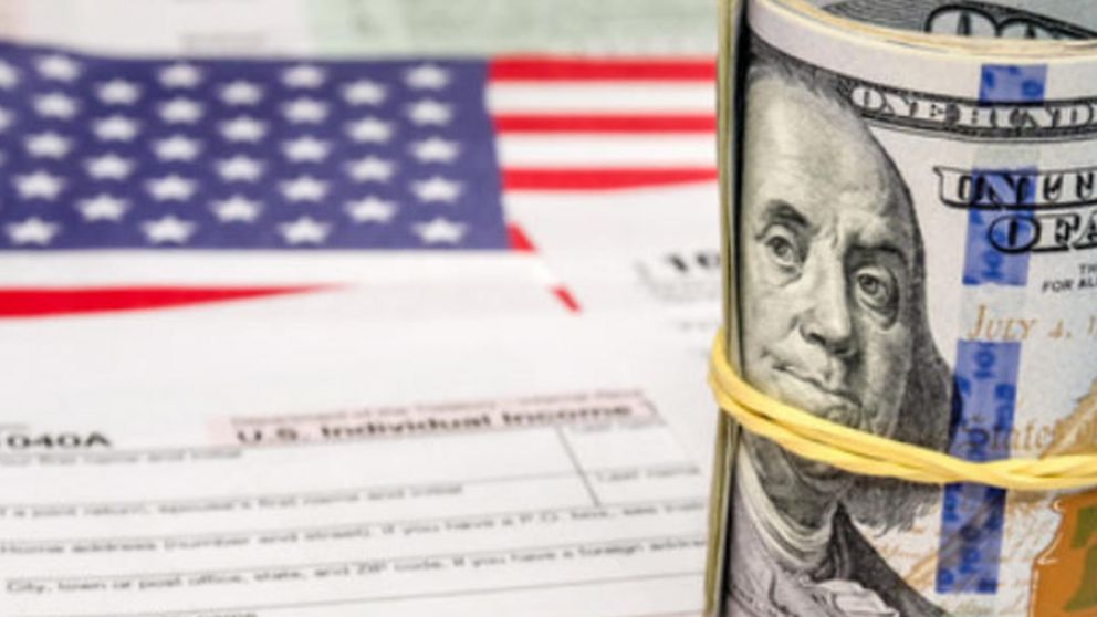 US Federal Income 1040 tax return form with money, flag