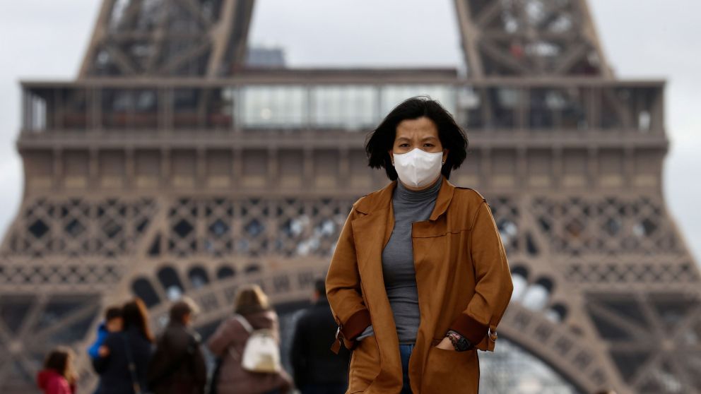 A woman wears a protective mask in light of the coronavirus outbreak in China as she walks at the Trocadero esplanade in front of the Eiffel Tower in Paris