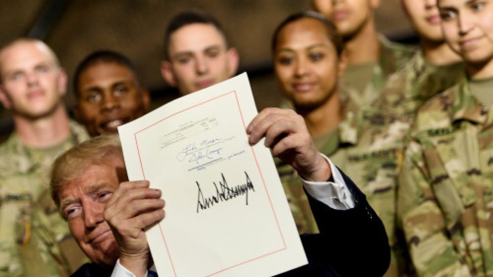 El presidente muestra su firma en la promulgación de la norma sobre Defensa