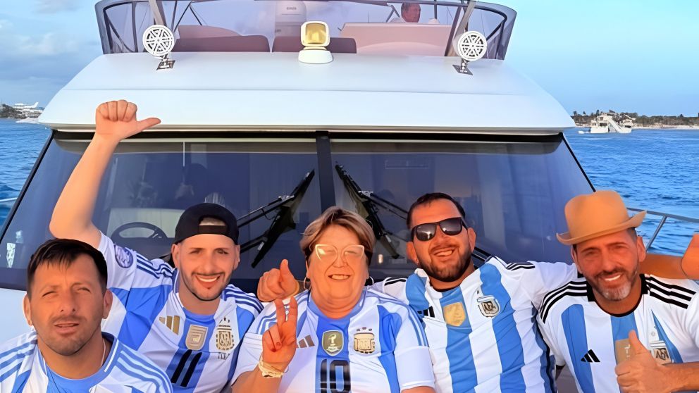 A bordo de un yate, Ana Lucía Conte aparece en el centro con la camiseta número 10 y, a su derecha, Luciano Pantano levanta el brazo
